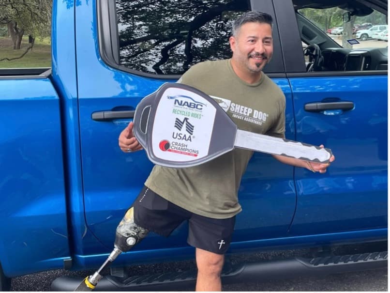 USMC Veteran Eric Morante posing next to the 2021 Chevrolet Silverado he was gifted.