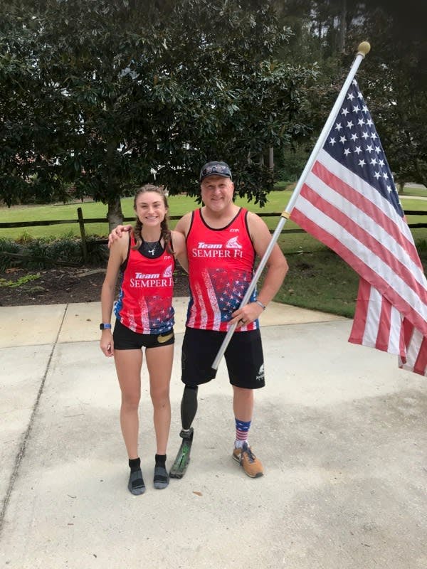Pete Way with daughter and American flag posing after a footrace.