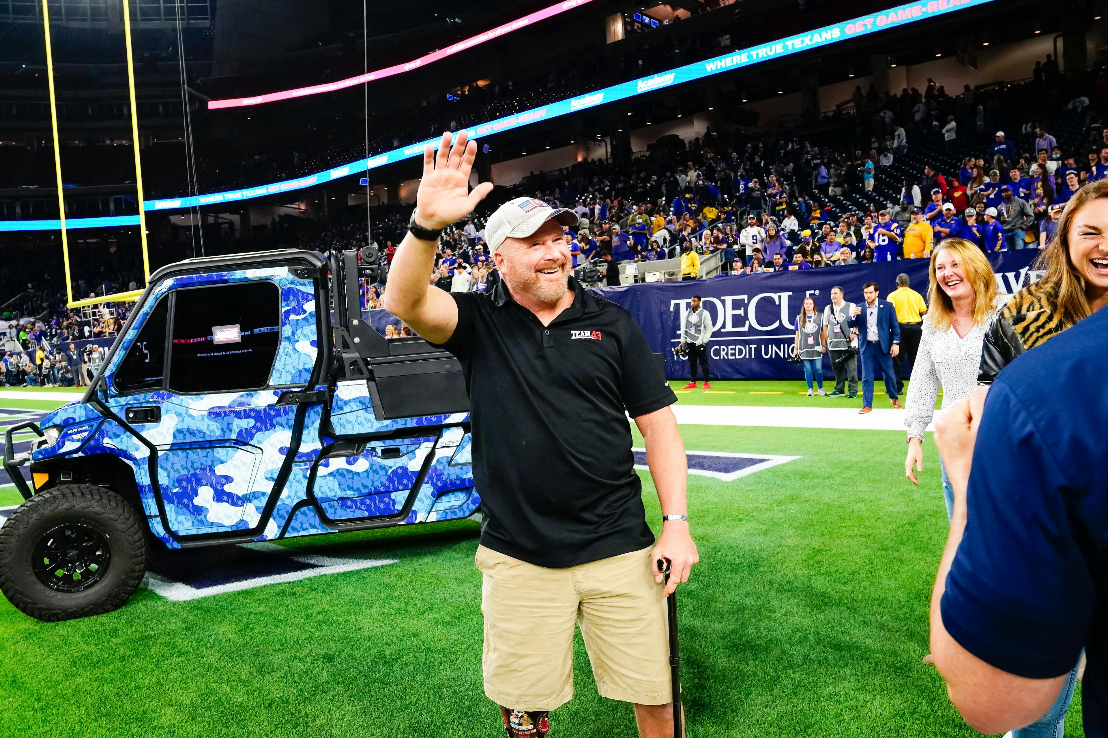 Pete Way being presented with a UTV at a college bowl game.